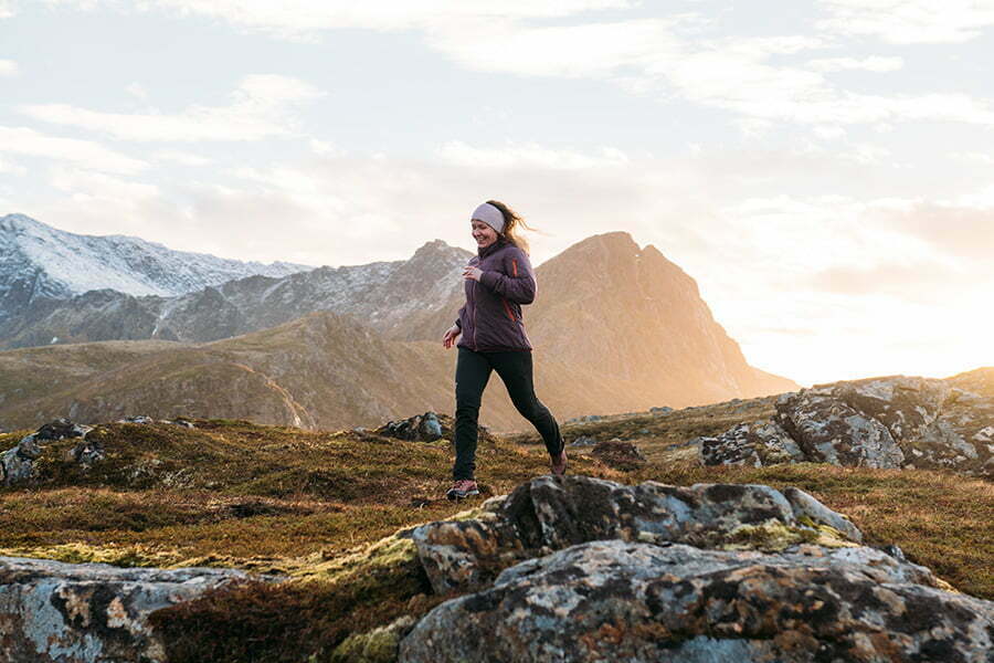 Kvinne som daglig tar Zooca®️ omega-3 tilskudd løper i fjellet.