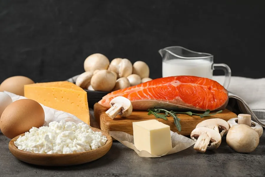 Kilder til vitamin D. Bilde av laks, sopp, ost, smør, egg og et glass med melk